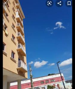 a building and a blue sky with a cloud in the sky at Apartamento Beira mar in Fortaleza