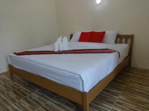 łóżko z czerwono-białymi poduszkami w obiekcie ST Mansion w mieście Khanom