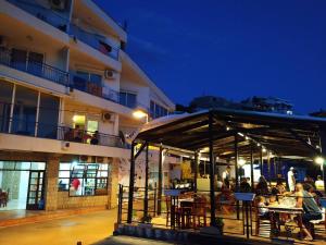 a group of people sitting at tables outside of a building at Apartmani Orange Dreams in Sutomore +57 photos