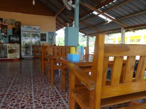 a dining room with wooden tables and benches at ST Mansion in Khanom