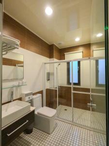 a bathroom with a shower and a toilet and a sink at 澎湖夏日南風民宿 in Magong