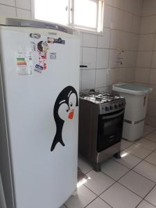 a refrigerator with a penguin on it in a kitchen at Apartamento Beira mar in Fortaleza