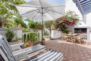 een patio met een parasol en een tafel en stoelen bij Mi Casa in Caleta De Velez