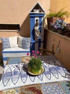 a table with a bird in a blue bird feeder at Casetta del borghetto -Nel cuore del Borghetto in Nettuno