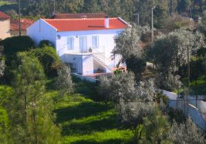 uma casa branca com um telhado vermelho numa colina em Casas d'Almofala em Vila de Rei