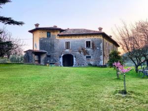 an old stone building on a grass field at Agriturismo Cervano in Toscolano Maderno