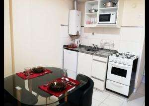 a small kitchen with a table and a stove at Departamento centrico sobre calle principal in San Miguel de Tucumán