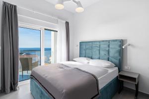 a bedroom with a large bed and a balcony at Aquarelle Apartments Primošten apt no 1 and 3 in Primošten