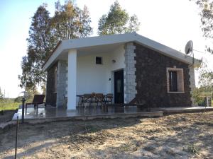 een klein huisje met een tafel en stoelen ervoor bij Sa Tanca de Su Catreathu in Orosei