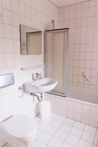 a white bathroom with a sink and a toilet at Ferienwohnung Meinersen in Meinersen