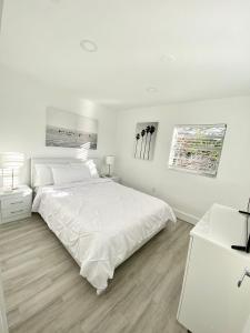 um quarto branco com uma cama grande e lençóis brancos em Modern Home, Excellent Location Miami em Miami