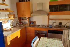 a kitchen with wooden cabinets and a table in it at Pace tra gli ulivi e il mare in Sori +15 photos