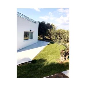een wit huis met een raam en een tuin bij Villa with fantastic view in Perea