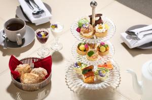 two tiers of pastries on a table with a cup of coffee at Baccarat Hotel and Residences New York in New York