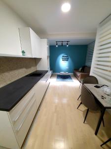 a kitchen with white cabinets and a table and a couch at Aleksandar First Sea Line Apartment in Bar