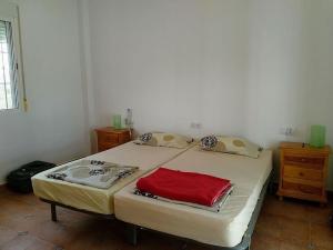 - une chambre avec un lit et une serviette rouge dans l'établissement Belvilla by OYO Casa de Aguila, à Almogía