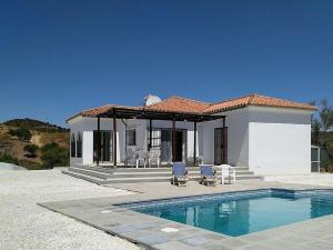 una casa con piscina frente a ella en Belvilla by OYO Casa de Aguila en Almogía