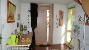 um quarto com uma porta, uma mesa e uma janela em Chambre d'Hotes Le Vogelgarten em Sigolsheim