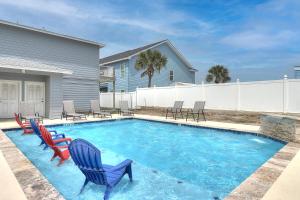 einen Pool mit Stühlen und ein Haus in der Unterkunft X Marks The Spot in Port Aransas