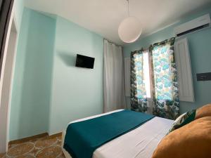 ein kleines Schlafzimmer mit einem Bett und einem Fenster in der Unterkunft AFFITTACAMERE PIAZZA MAMELI in Torre Lapillo
