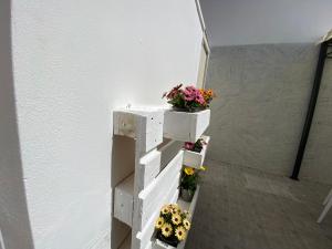 eine weiße Treppe mit Blumen in Töpfen darauf in der Unterkunft AFFITTACAMERE PIAZZA MAMELI in Torre Lapillo