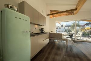 a kitchen with a white refrigerator and a table at latemar - schlosserhaus 31 in Tesimo