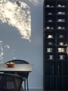 a dining room with a table and a shelf with cups at Domìa Boutique Hotel e Cucina in Mondello