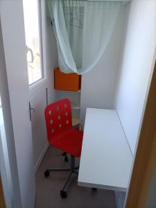 a red chair in a room with a mirror at STUDIO Cosy et fonctionnel, proche de Paris in Villeneuve-la-Garenne