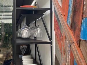 a black shelf with bowls and plates on it at Domìa Boutique Hotel e Cucina in Mondello