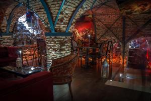 un ristorante con tavolo, sedie e muro di mattoni di Casa Albert Boutique & Restaurant a Braşov