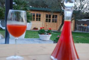 una copa de vino sentada en una mesa junto a una botella de ketchup en Le Cerbaie - Casa Vacanze, en Lamporecchio