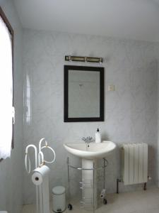 y baño con lavabo blanco y espejo. en Casas del Parador - Las Eras, en Villanueva del Conde