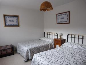 1 dormitorio con 2 camas y lámpara en Casas del Parador - Las Eras, en Villanueva del Conde