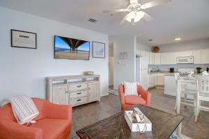 a living room with two orange chairs and a kitchen at Yachta-Yachta in Port Aransas