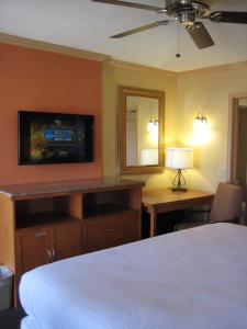 a bedroom with a bed and a desk and a tv at Americas Best Value Inn - Porterville in Porterville