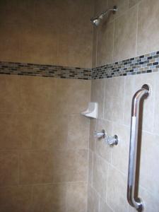 a bathroom with a shower with a tiled shower at Americas Best Value Inn - Porterville in Porterville