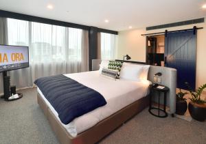 um quarto com uma cama grande e uma televisão em Sudima Auckland City em Auckland