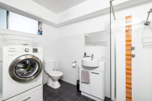 a bathroom with a washing machine and a sink at Sea Breeze with City Ease in Port Lincoln