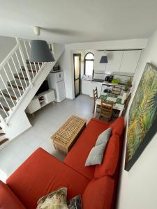 ein Wohnzimmer mit einem roten Sofa und einer Küche in der Unterkunft Casa Ozzy in Costa Calma