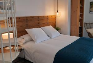 een slaapkamer met een wit bed met een houten hoofdeinde bij Casa Carmen in Laroles