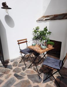 una mesa y dos sillas con plantas. en Casa Carmen, en Laroles