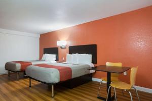 a room with two beds and a table with chairs at Motel 6-Suwanee, GA - Gwinnett Center in Suwanee +33 photos