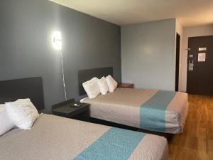 a hotel room with two beds and a lamp at TROYINN&SUITES in Troy