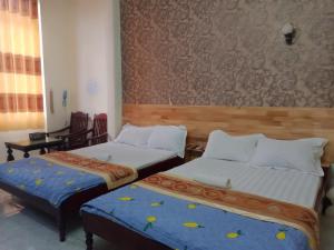 two beds in a hotel room with at Khách sạn Duy Hoàng in Buon Ma Thuot