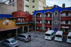 un groupe de voitures garées devant un bâtiment dans l'établissement Hotel Hacienda de Cobos, à Guanajuato
