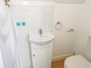 a white bathroom with a sink and a toilet at Dunromin in Llandudno +22 photos