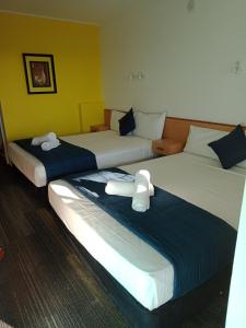 Tempat tidur dalam kamar di Annerley Motor Inn