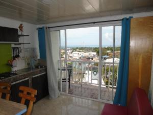 cocina con una gran puerta corredera de cristal y balcón en Mi buena Vista, en San Andrés