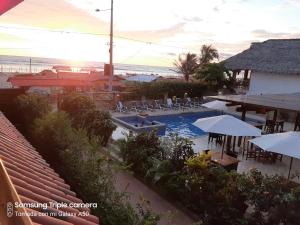 una piscina con sillas y sombrillas en un complejo en Hotel La Vista en Canoa