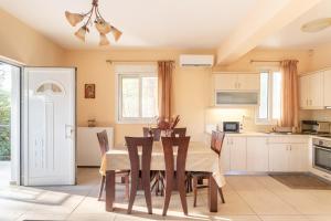 a kitchen with a dining room table and chairs at Maisonnette D'Amira in Eretria